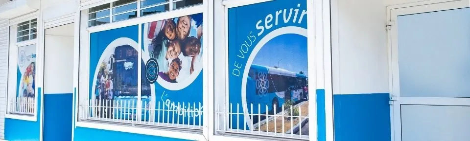 Vitrines de l’agence commerciale décorées du message « De vous servir ».